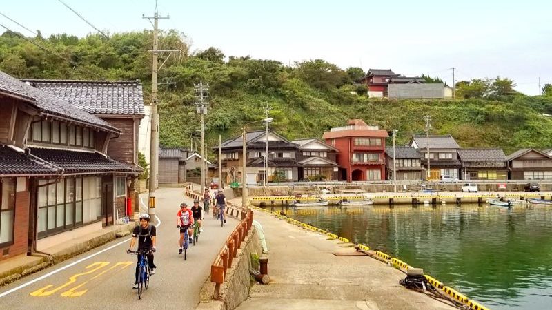 A group of cyclists riding through Togi, Japan