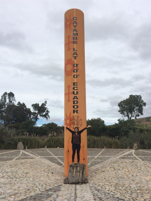 A woman standing at the equator in Ecuador