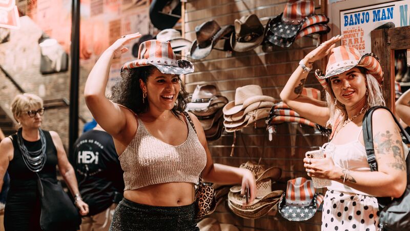 Two travellers trying on cowboy hats