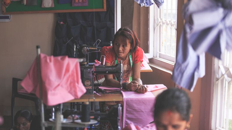 A woman taking a break from sewing clothes