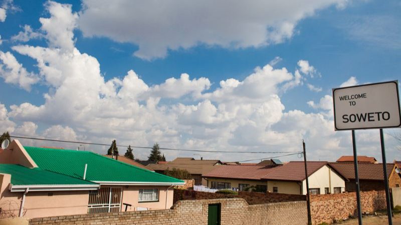 Low houses with a sign saying Welcome to Soweto.