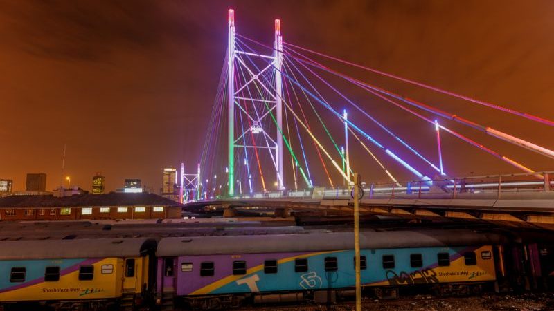 Brightly coloured bridge at night.