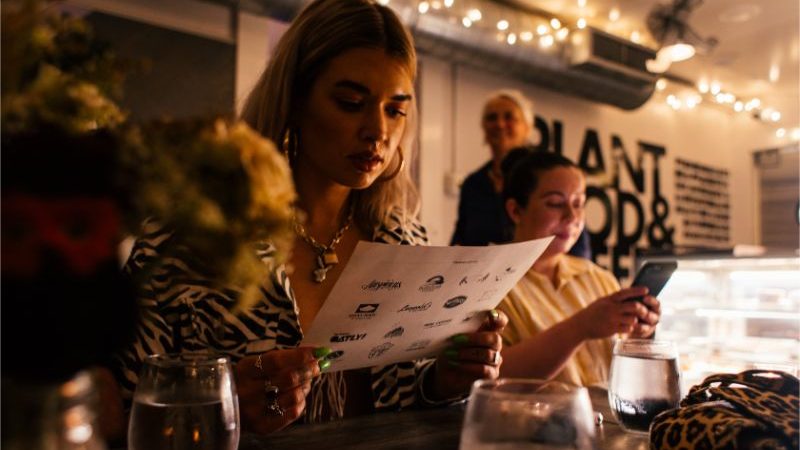 A young woman reading a menu in a restaurant