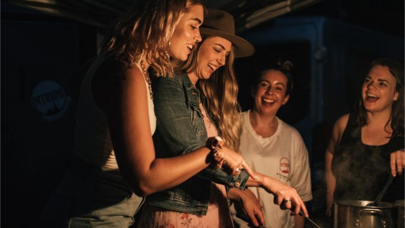 A group of women cooking at a camp site.