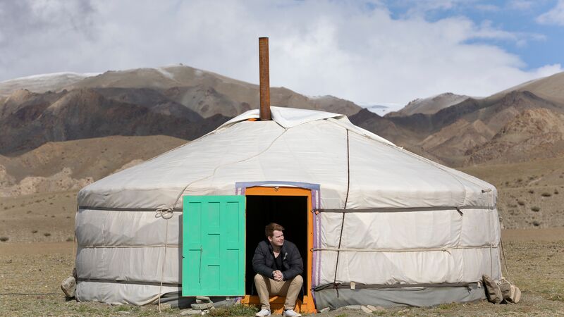A man sitting in the doorway of a ger in Mongolia