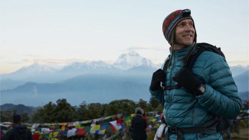 A man wearing a warm jacket, a head torch and a woolen hat in Nepal