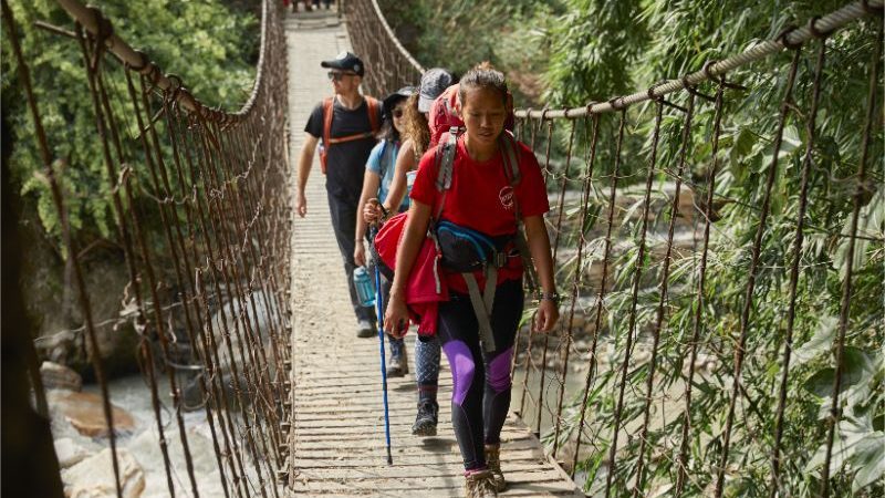 Trekkers cross a suspension bridge in Nepal