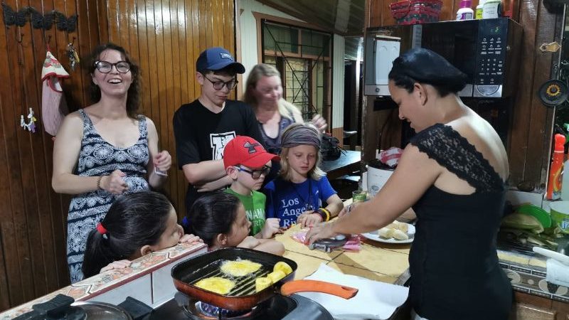 A group of people watching someone cook