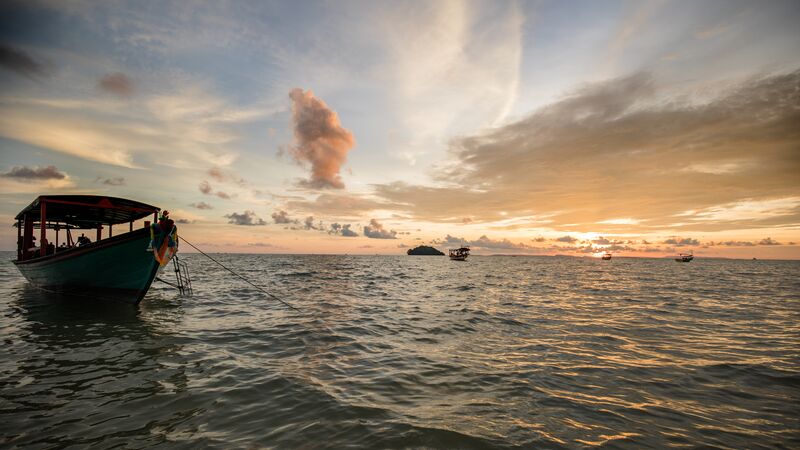 A boat and island at dusk.