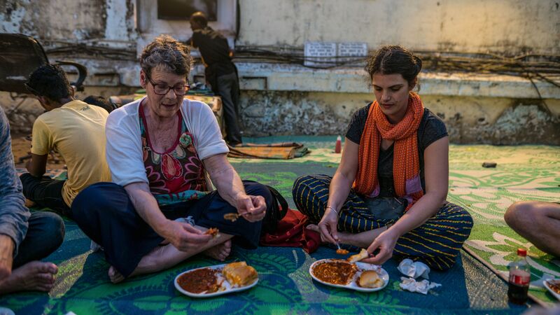 Female travellers eating on the floor in Goa