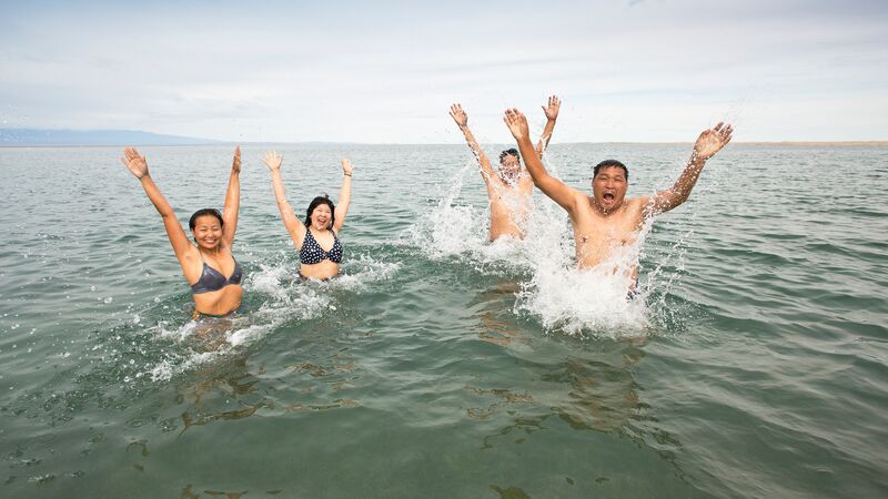 A group of travellers swimming in a lake in Mongolia