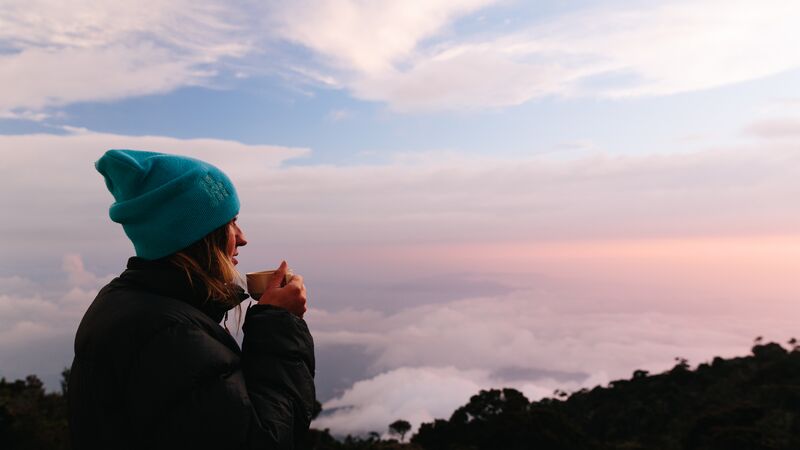 A young woman watching the sun rise at Mt Kinabalu