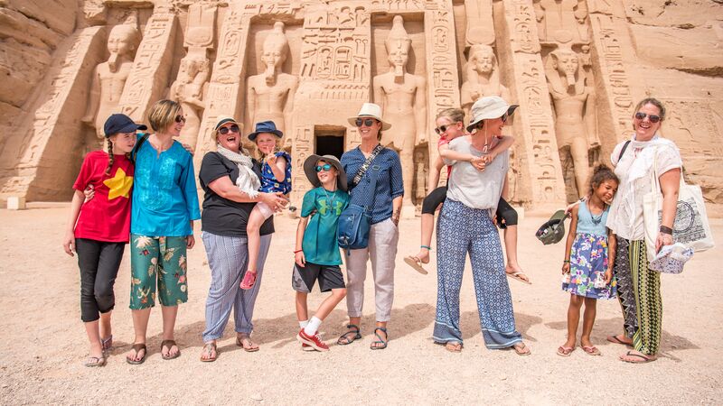 A group of travellers, including young children, at Abu Simbel temple in Egypt