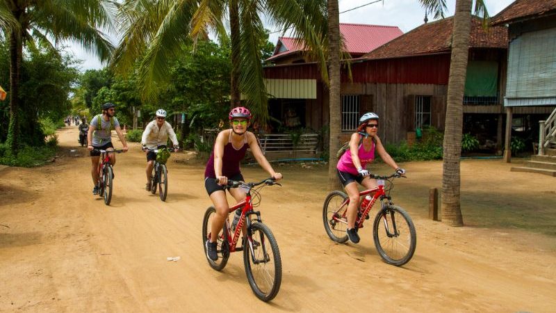 Cyclists riding through a village.