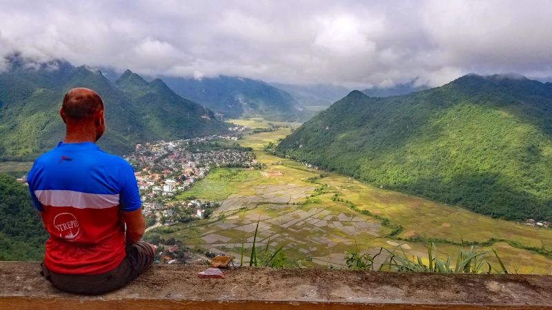 A cyclist looks out over rice paddies in Vietnam