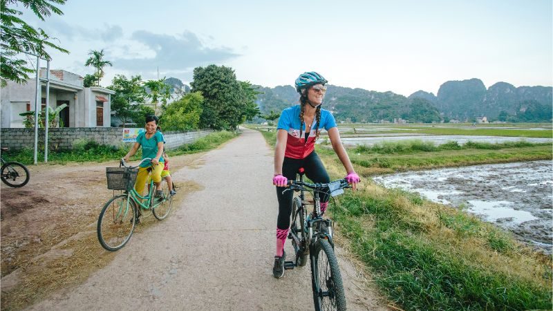 A cyclist riding past rice paddies in Vietnam