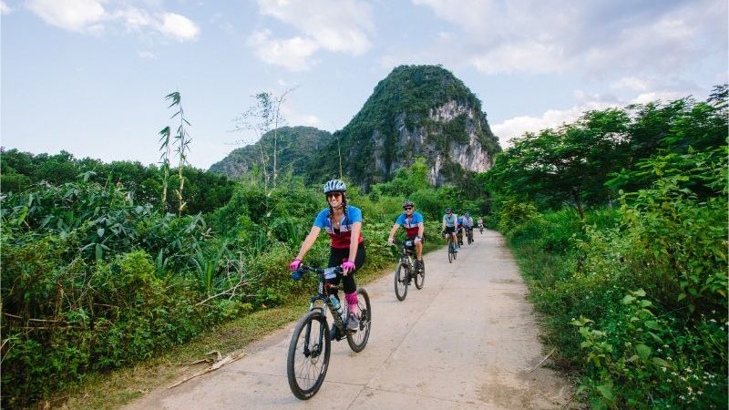 A group of cyclists riding through Mai Chau, Vietnam.