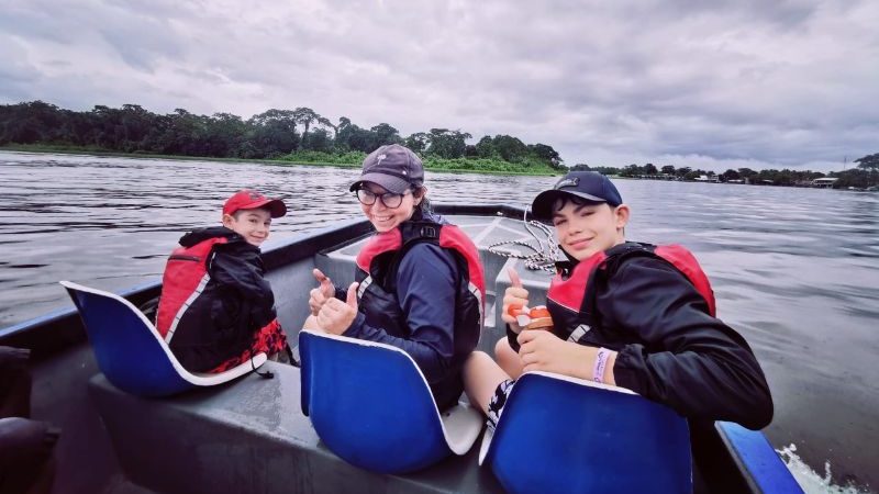 Three people on a boat in the rain