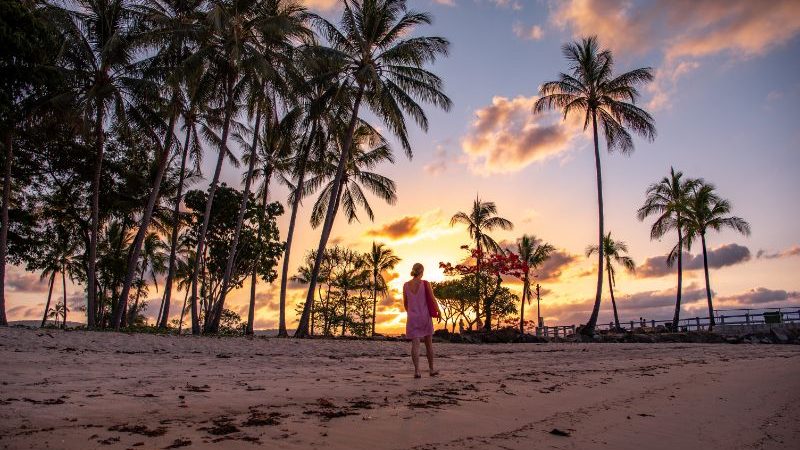 Traveller on the beach at sunset in Port Douglas.