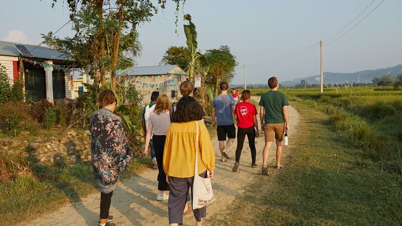 A group of travellers walking through a small village in Nepal.
