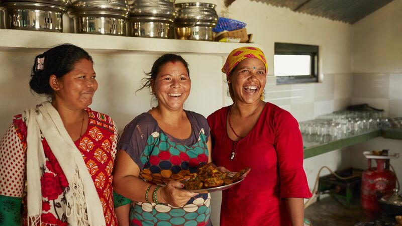 Three smiling women in a kitchen