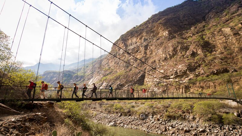 Trekkers crossing a bridge in Peru