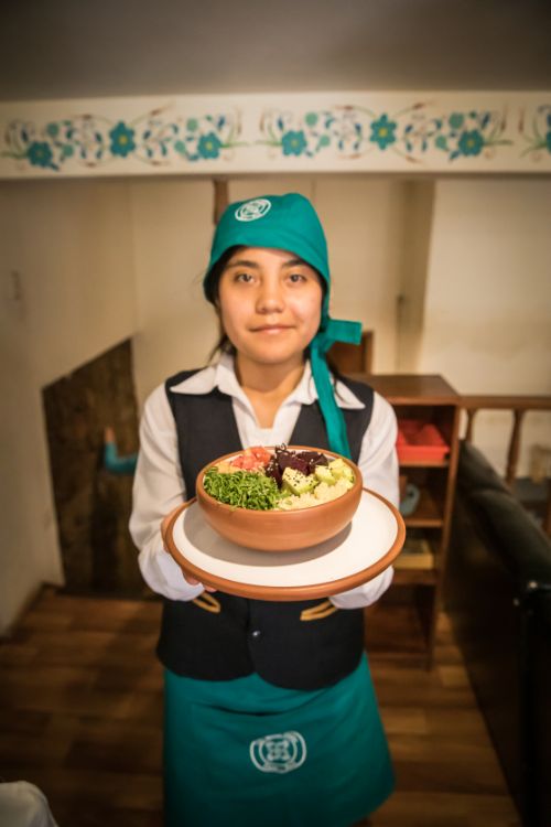 A young woman holds up a plate of food