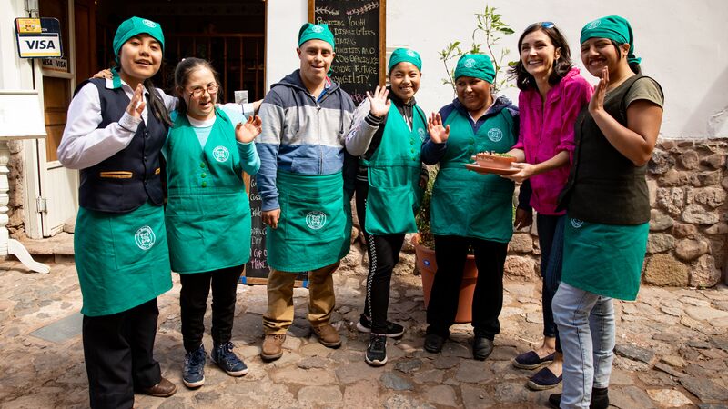 A group of wait staff standing outside a cafe in Peru