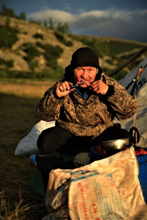 A local man in Siberia eating reindeer