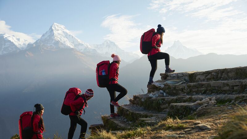 Four porters walking up a set of stairs in Nepal