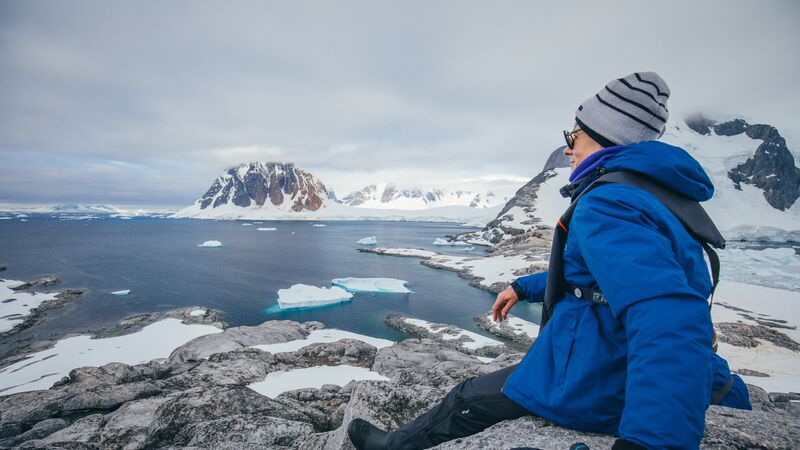 A traveller admiring the views of glaciers in Antarctica