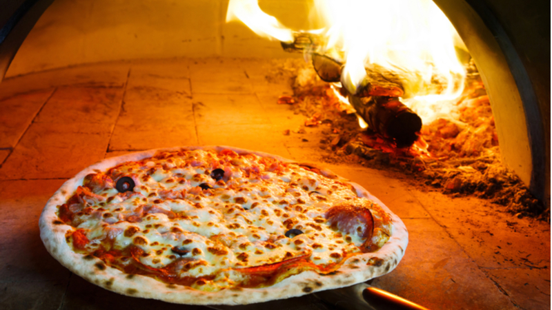 Wood fire cooked pizza with cheese, salami and olives for toppings.