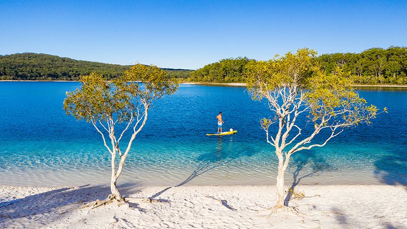 A person paddle boarding in Lake McKenzie