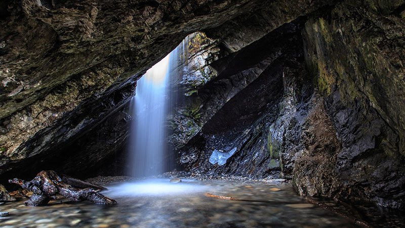 Sun shining through the circular hole in Donut Falls, Salt Lake City. 