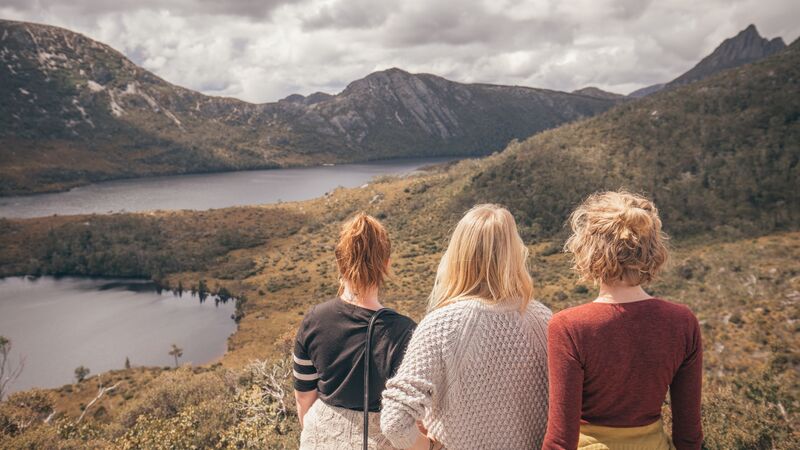 Three travellers looking out from Hansons Peak in Cradle Mountain, Tasmania. 