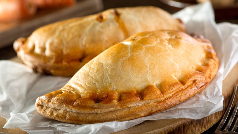 A Cornish pasty on a wooden plate