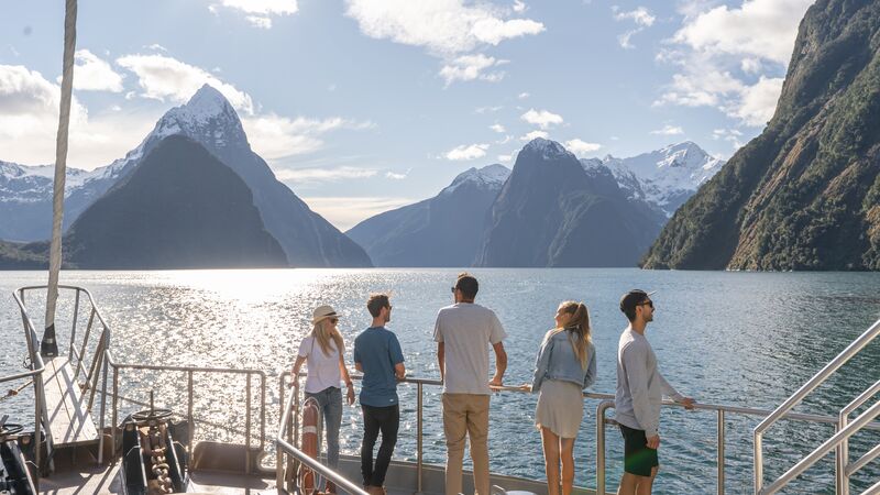 Intrepid travellers standing on the deck of a cruise ship in Milford Sound