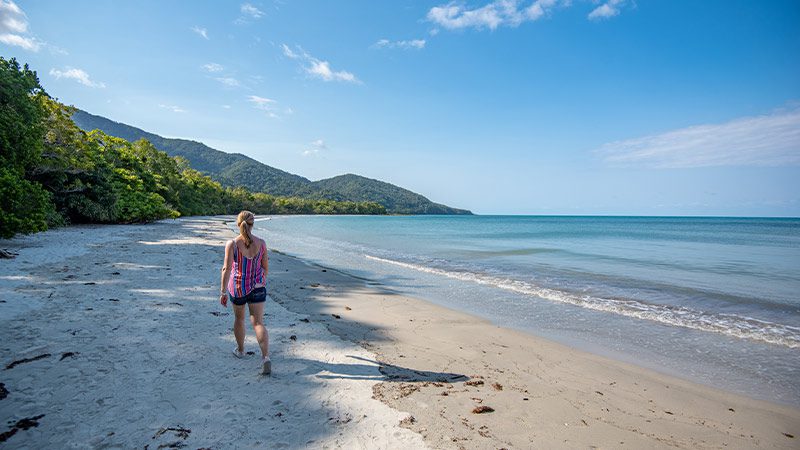 Traveller walking along Cape Tribulation in the Daintree.