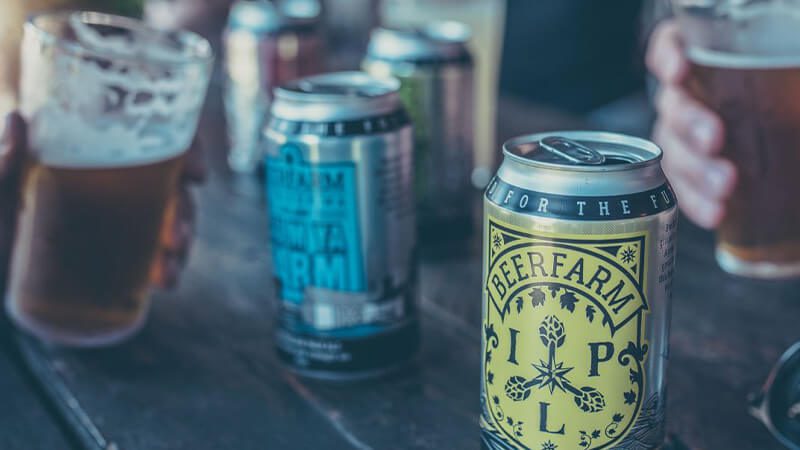 Cans and pints of Beerfarm beers on a table