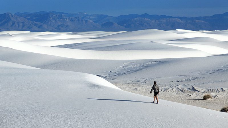 Man walking through the White Sands National Park.
