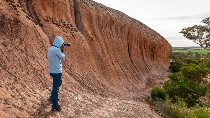 A traveller taking a photo of Pildappa Rock, SA