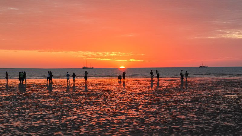 A group of people enjoying Mindil Beach at sunset. 