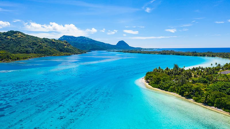 Aerial view of the French Polynesian Islands surrounded by sparkling, blue water