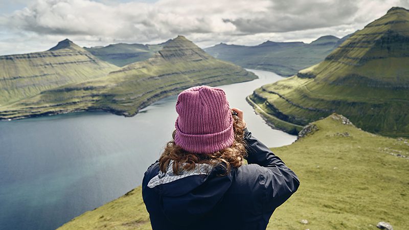 A photographer taking photos of a fjord in the Faroe Islands