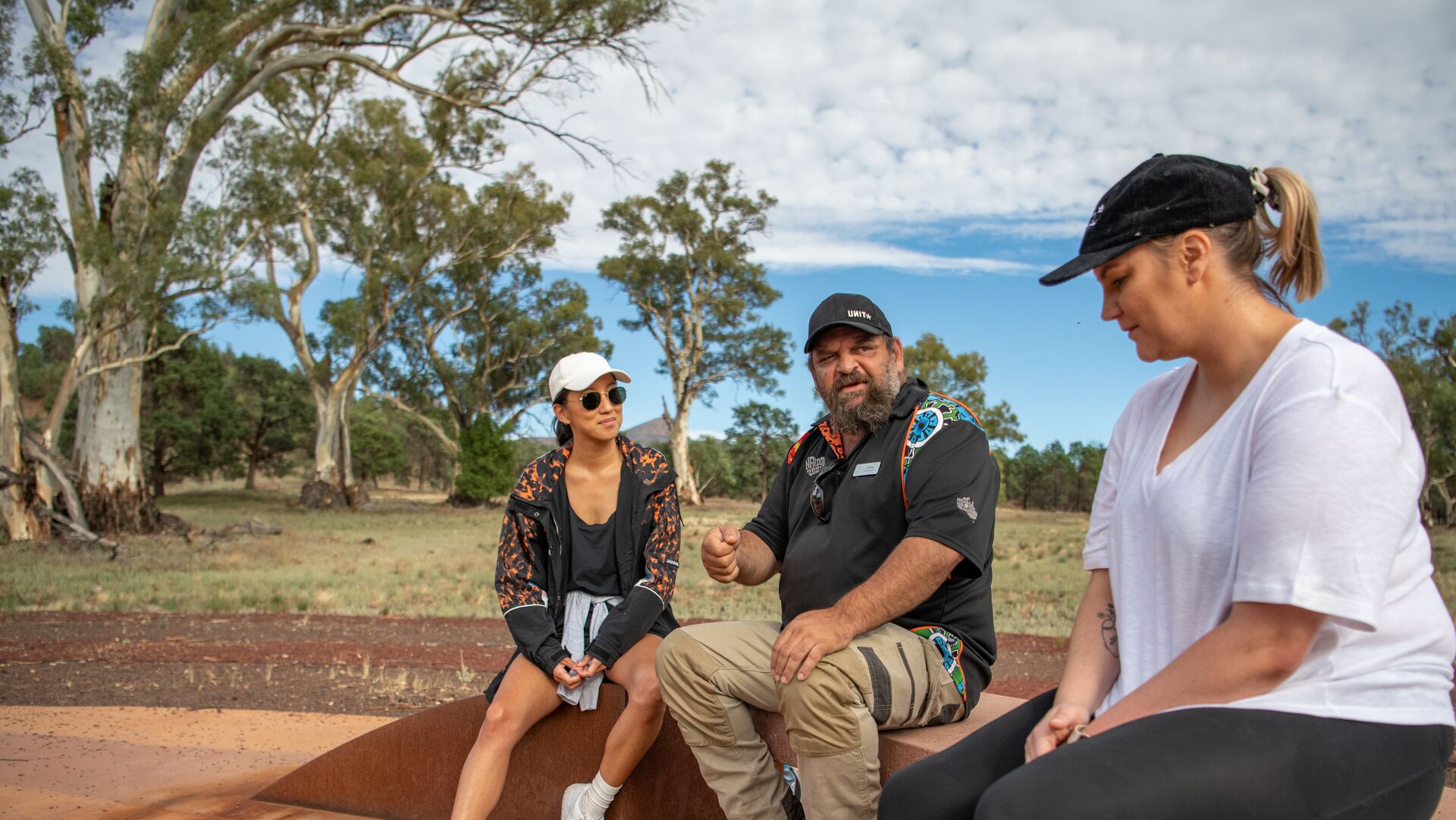 Adnyamathanha guide Vince Coulthard explains the sacred site of Wilpena Pound to two travellers.