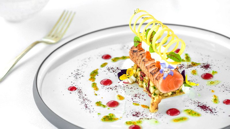 A perfectly presented salmon dish on an elegant plate from Le Sud.