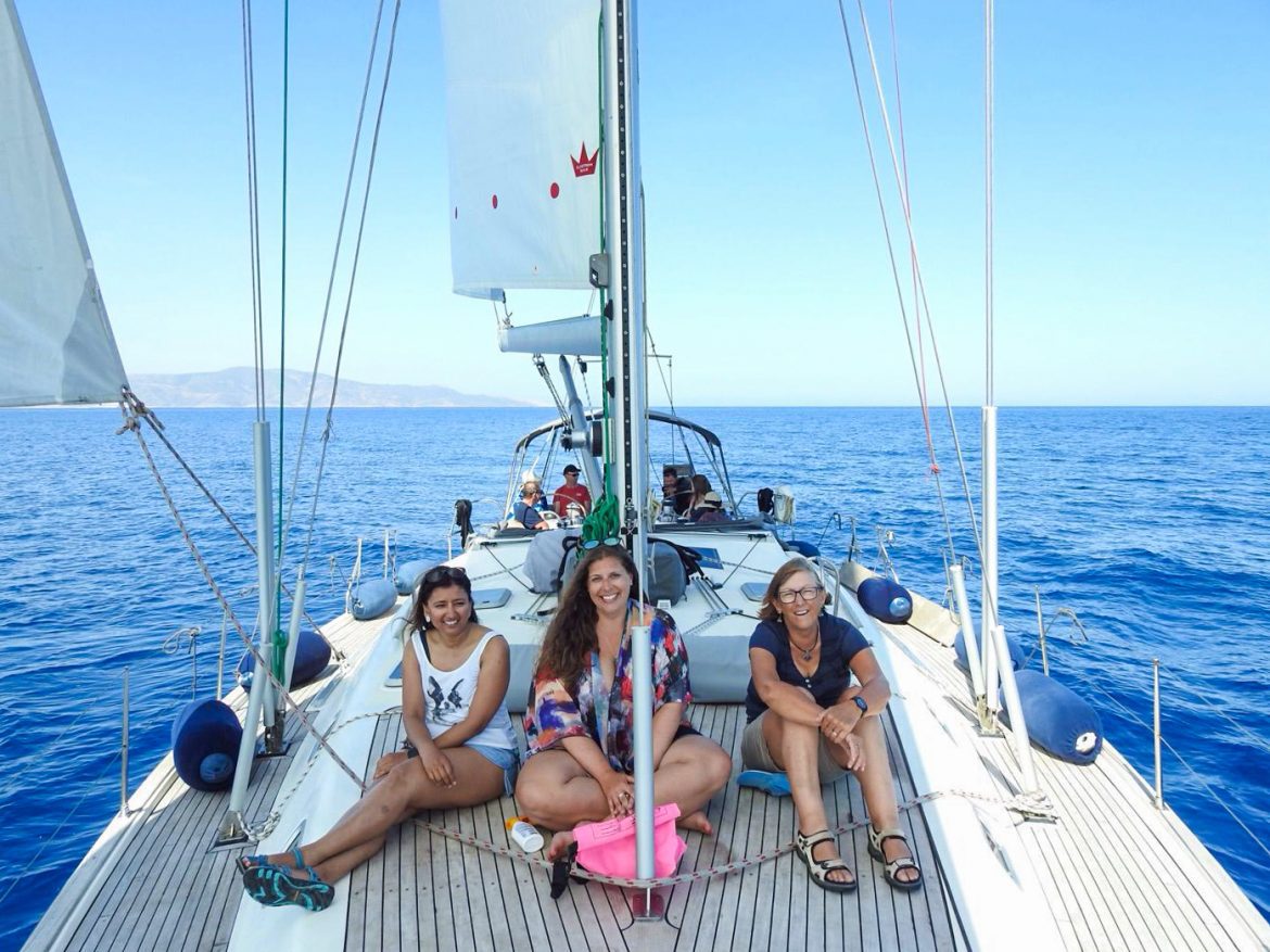 Three women sitting on a sail boat in Greece