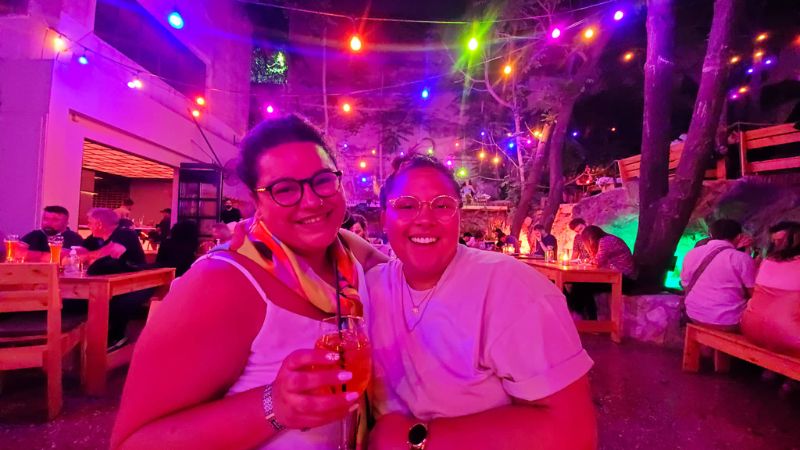 Two smiling women out at a nightclub.