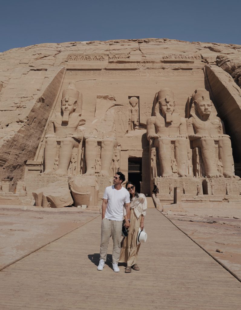 A smiling couple standing in front of an ancient monument in Egypt