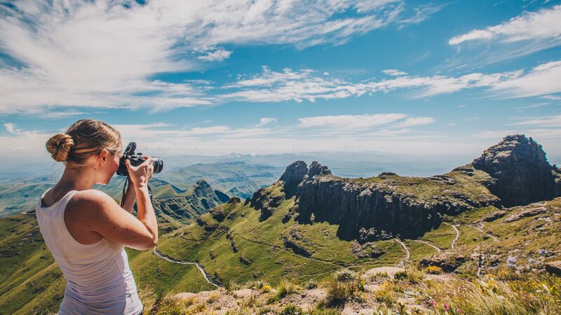A woman photographing the view of the Drakensberg in South Africa